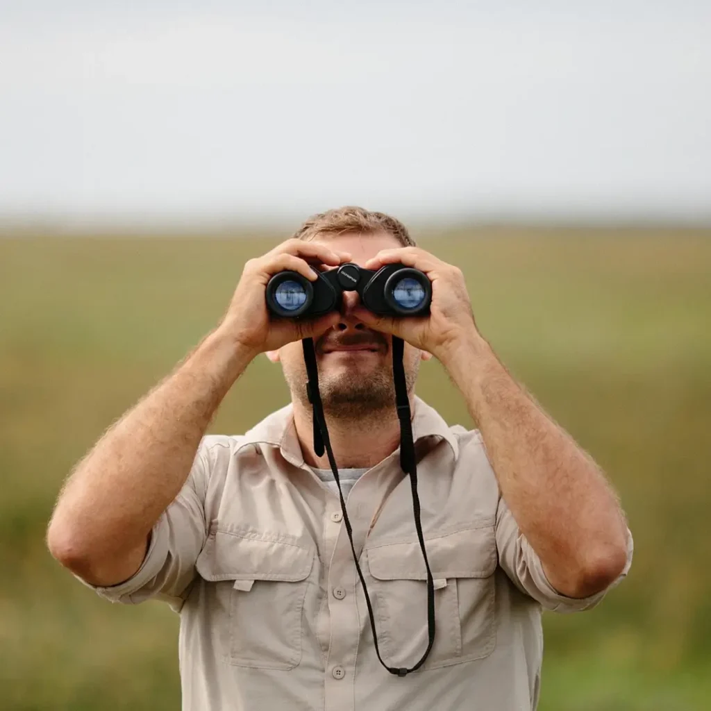 hombre mirando a través de prismáticos